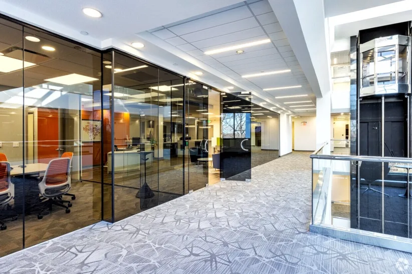 Glass-walled offices along a bright hallway